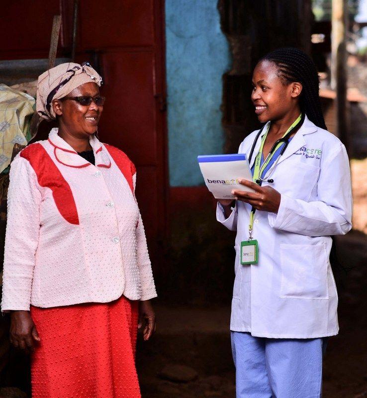 A photo of an elderly woman and a nurse talking to each other